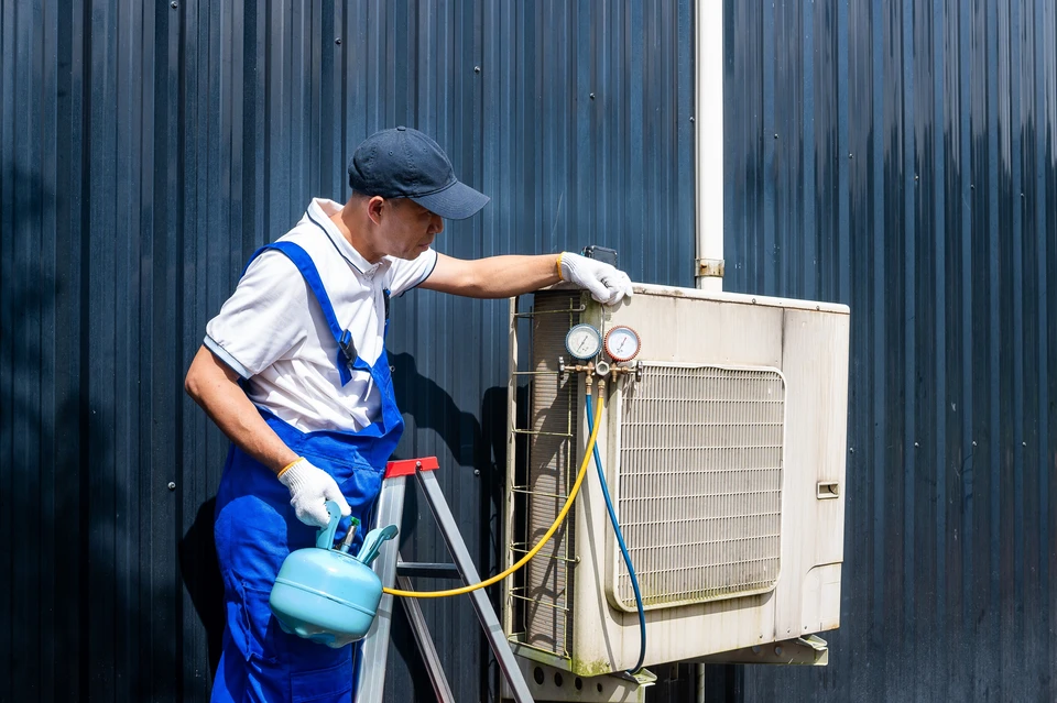 Unité extérieure de pompe à chaleur air/eau installée contre le mur d'une maison individuelle